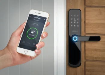 Mulher aciona fechadura inteligente pelo celular. Falando sobre sistema de segurança residencial inteligente.
