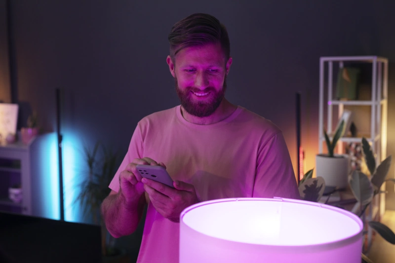 Homem acende luminária inteligente. Falando sobre iluminação inteligente.