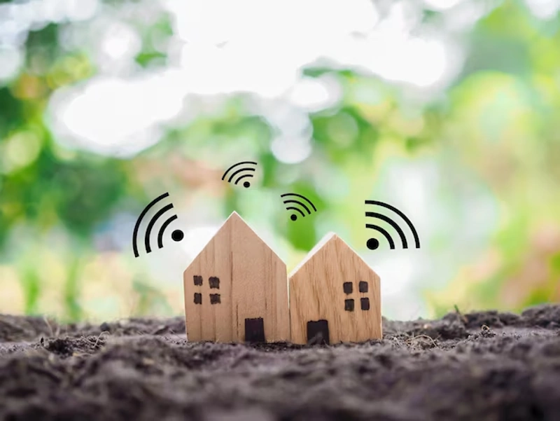 Duas casinhas de madeira no chão de uma área rural. Sinais de Wi-Fi digitalmente incluídos sobre elas. Falando sobre wi-fi para casa inteligente.